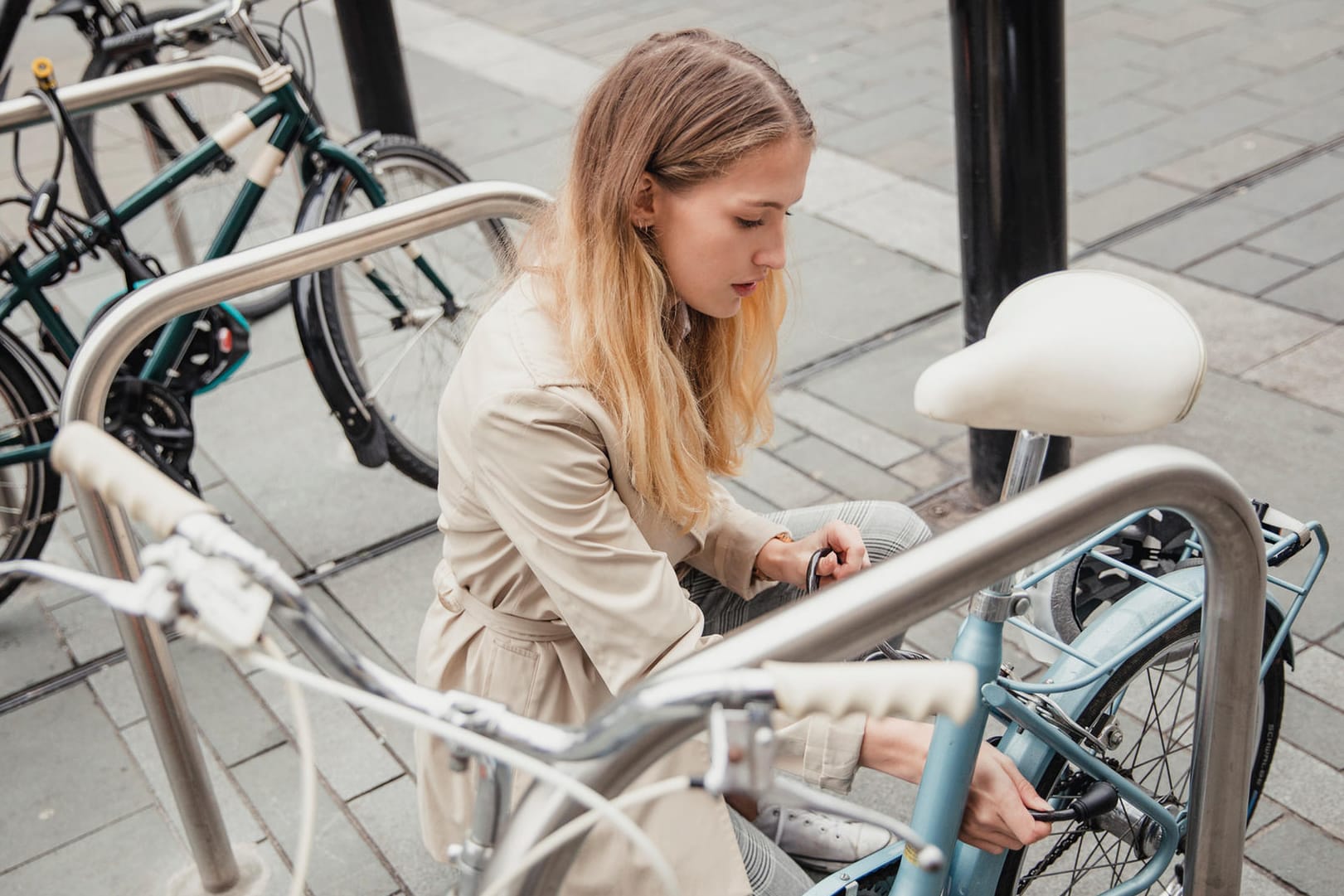 Frau schließt Fahrrad ab: Experten raten, Räder möglichst immer doppelt mit unterschiedlichen Schlosssystemen abzusichern.