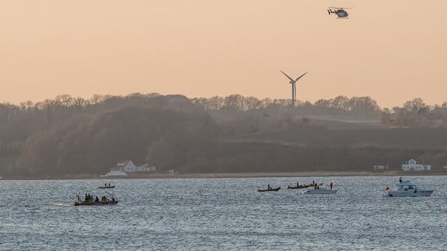 Helfer suchen mit einem Hubschrauber und Booten auf der Förde bei Glücksburg das Wasser ab, nachdem hier ein Ruderboot gekentert war.