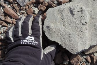 Ein Forscher greift nach einem rund 200 Millionen Jahre alten versteinerten Saurier-Fußabdruck, der auf einer Antarktis-Expedition entdeckt wurde.