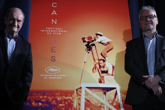 Festivaldirektor Thierry Frémaux (r) und Festivalpräsident Pierre Lescure vor dem offiziellen Cannes-Plakat, das die verstorbene Regisseurin Agnès Varda zeigt.