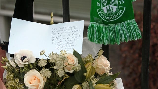 Blumen und eine Karte am Tatort erinnern an Bradley Welsh.