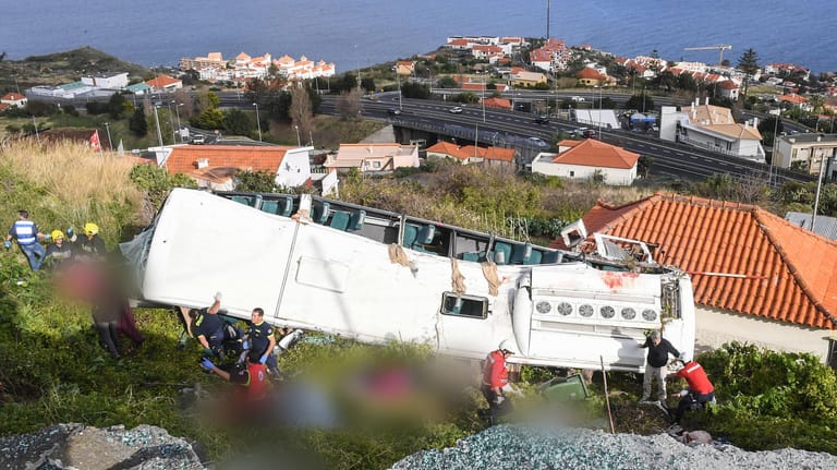 Portugal, Canico: Rettungskräfte stehen nach einem schweren Busunglück auf der portugiesischen Ferieninsel Madeira an dem Bus. Bei dem Busunglück auf der portugiesischen Atlantikinsel Madeira sind 29 Menschen ums Leben gekommen.
