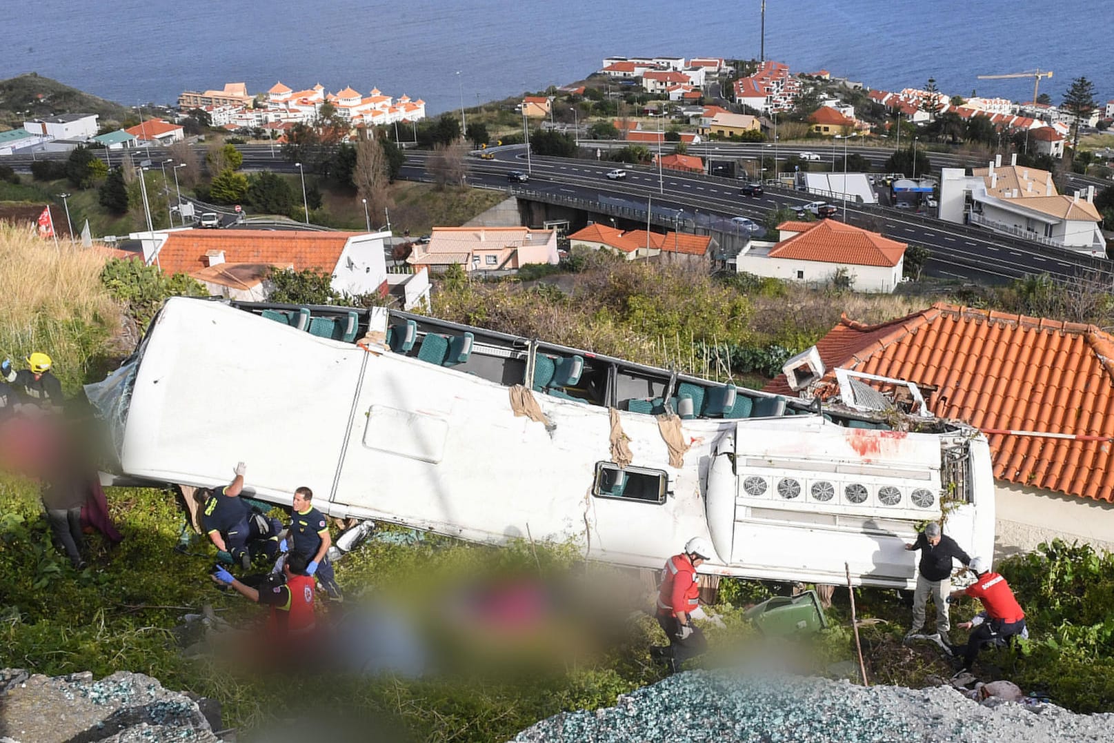 Portugal, Canico: Rettungskräfte stehen nach einem schweren Busunglück auf der portugiesischen Ferieninsel Madeira an dem Bus. Bei dem Busunglück auf der portugiesischen Atlantikinsel Madeira sind 29 Menschen ums Leben gekommen.