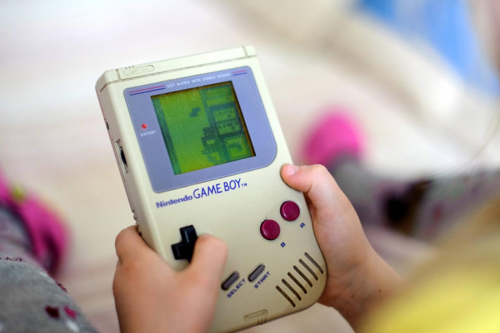 Ein Kind spielt auf einem originalen Game Boy das Spiel Tetris. Sind Sie auch nicht um einen Game Boy herum gekommen?