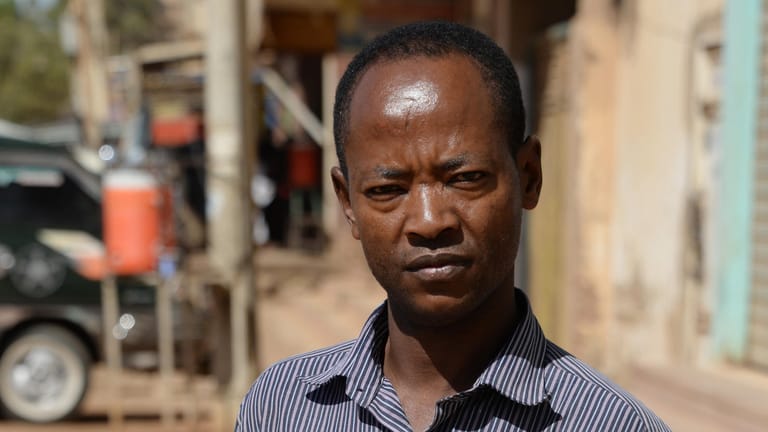 Ali Ahmed Jamal Jehad steht vor einem Bürogebäude, in dem er als eine Art Hausmeister arbeitet. Jehad stammt aus Äthiopien und ist vor rund zehn Jahren in den Sudan gekommen in der Hoffnung, nach Libyen und weiter nach Europa zu reisen.
