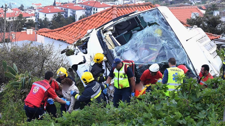 Rettungskräfte bergen Verletzte nach einem schweren Busunglück auf der portugiesischen Ferieninsel Madeira. Mindestens 29 Menschen überlebten die Tragödie nicht.