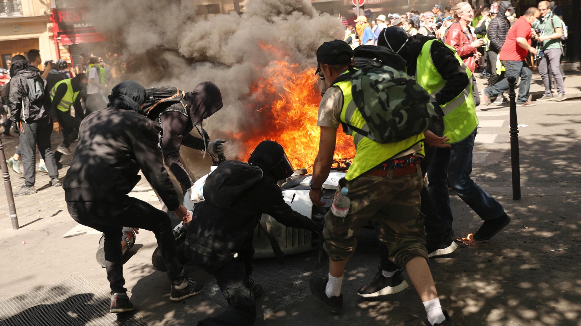 Teilnehmer der Demonstration stehen vor einem brennenden Motorrad: Am 20.04.2019 fanden erneut «Gelbwesten»-Demonstrationen in Paris statt.