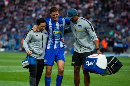 Herthas Niklas Stark (M) wird gegen Hannover verletzt vom Platz gebracht.