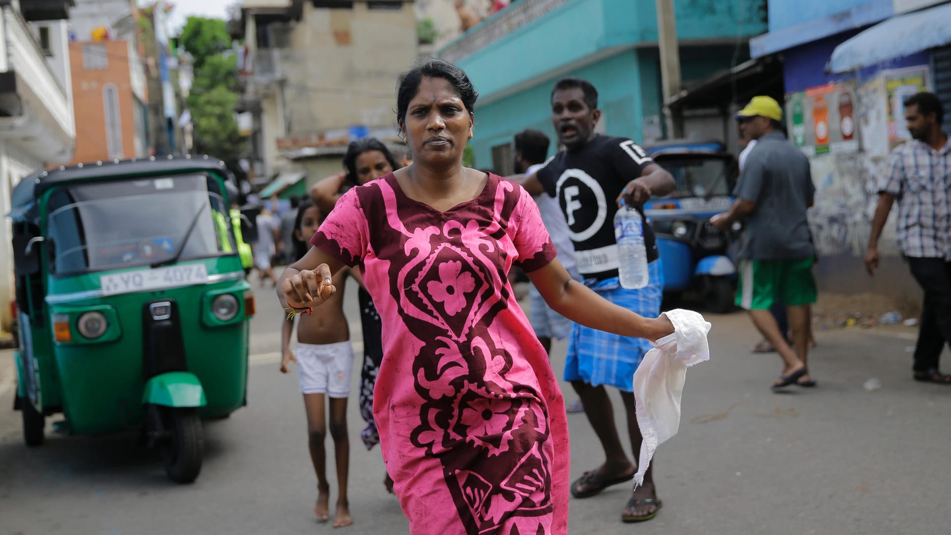 Eine Straße in Colombo: Eine srilankanische Frau, die in der Nähe des St-Antonius-Kirche wohnt, läuft in Sicherheit. Am Ostermontag fand die Polizei weitere Sprengsätze in einem in der Nähe der Kirche geparkten Fahrzeug.