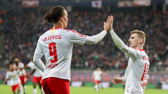 Leipzigs Yussuf Poulsen (l) klatscht nach einem Treffer mit Timo Werner an.