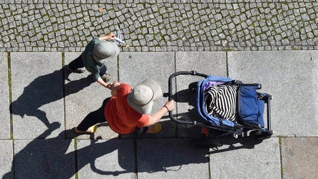 Eine Frau und ein Kind auf einem Gehweg.