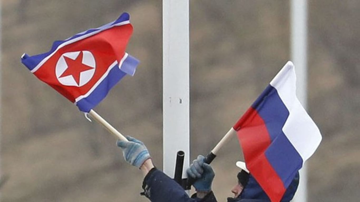 Vorbereitung auf das Treffen: Ein Arbeiter bringt an einer Straße auf der Insel Russki vor Wladiwostok die Flaggen von Russland und Nordkorea an.