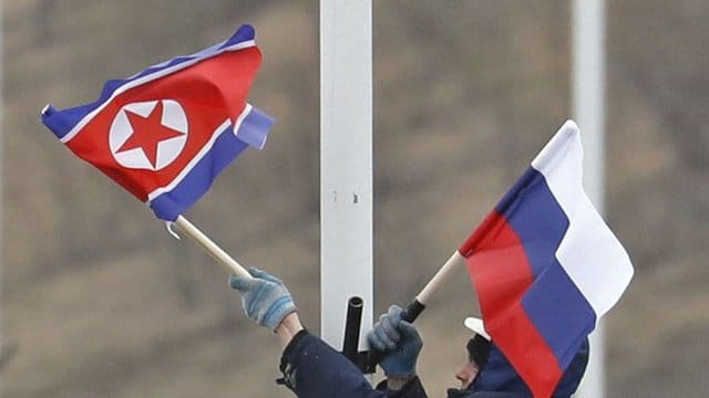 Vorbereitung auf das Treffen: Ein Arbeiter bringt an einer Straße auf der Insel Russki vor Wladiwostok die Flaggen von Russland und Nordkorea an. Vorbereitung auf das Treffen: Ein Arbeiter bringt an einer Straße auf der Insel Russki vor Wladiwostok die Flaggen von Russland und Nordkorea an.