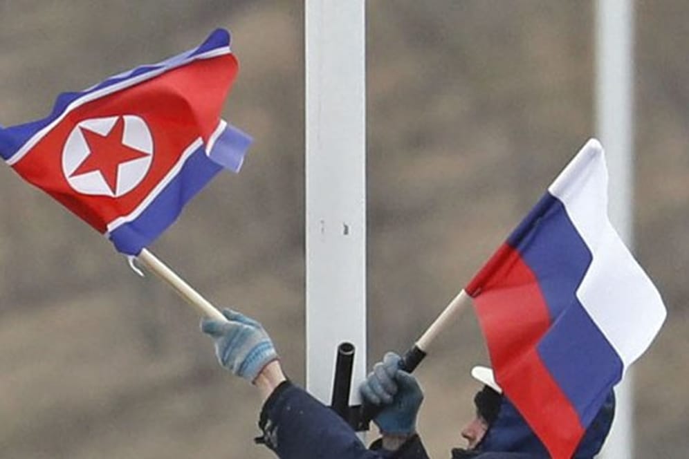 Vorbereitung auf das Treffen: Ein Arbeiter bringt an einer Straße auf der Insel Russki vor Wladiwostok die Flaggen von Russland und Nordkorea an.