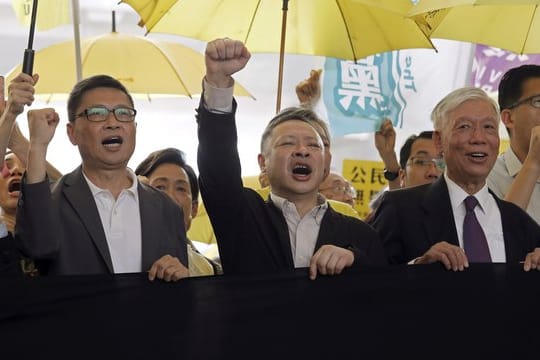 Die Anführer der "Regenschirm-Bewegung", Chan Kin Man (l-r), Benny Tai und Chu Yiu Ming rufen Parolen, bevor sie ins Gericht gehen.