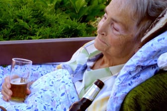 Rentnerin im Bett mit Bier: Neben Alkohol können Senioren auch von Beruhigungsmittel abhängig sein und bedürfen einen entsprechenden Umgang. (Symbolbild)