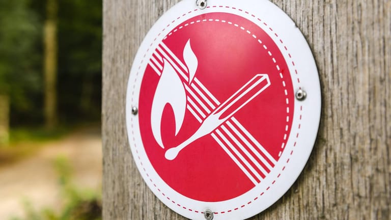 Verbotsschild: Lager- und Grillfeuer sind nur an gekennzeichneten Feuerstellen erlaubt. Ansonsten darf im Wald und am Wald kein Feuer entfacht werden.