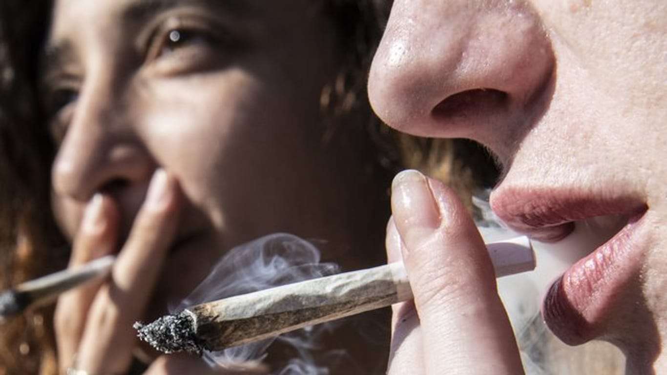 Zwei Frauen rauchen bei einer Protestaktion für legalen Cannabis-Konsum einen Joint.
