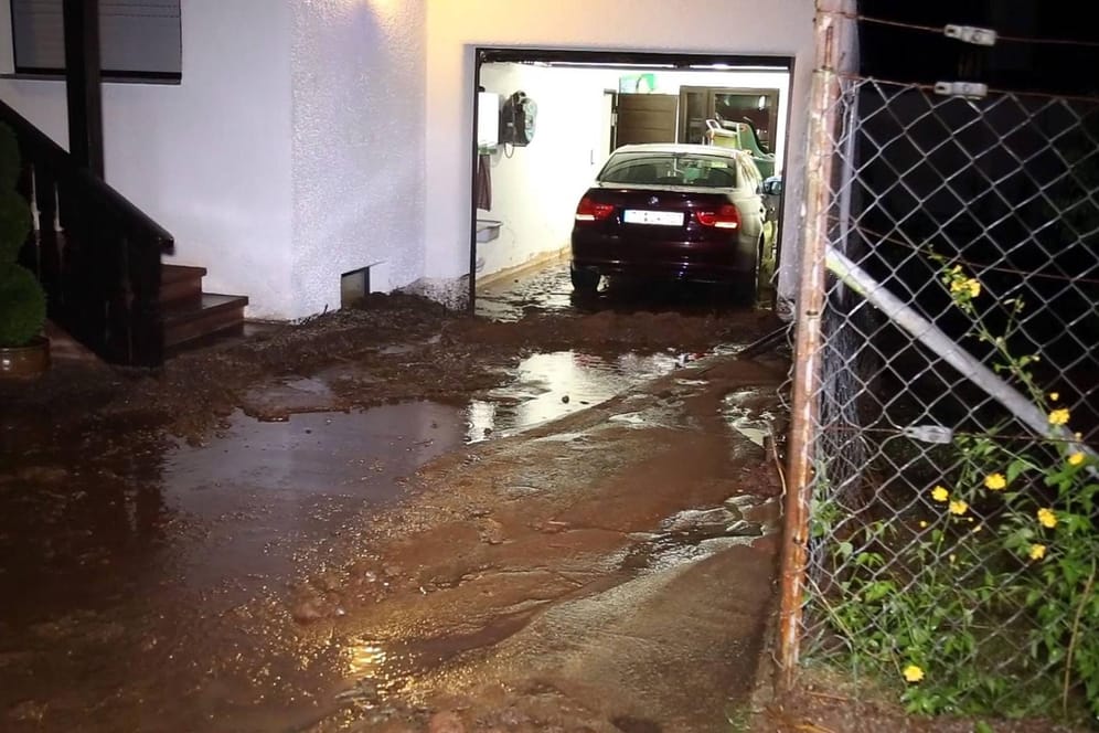 Wasser läuft in Garage: Wohngrundbesitzer müssen bestimmte Pflichten beachten, damit Starkregen keine Schäden verursachen kann.