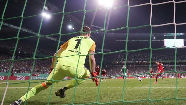 Bremens Torwart versucht einen Elfmeter zu parieren. Bremens Torwart versucht einen Elfmeter zu parieren.