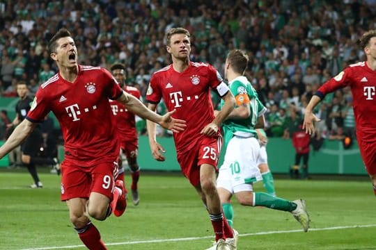 Thomas Müller (M) feiert mit Elfmeterschütze Robert Lewandowski (l) das 3:2 in Bremen.