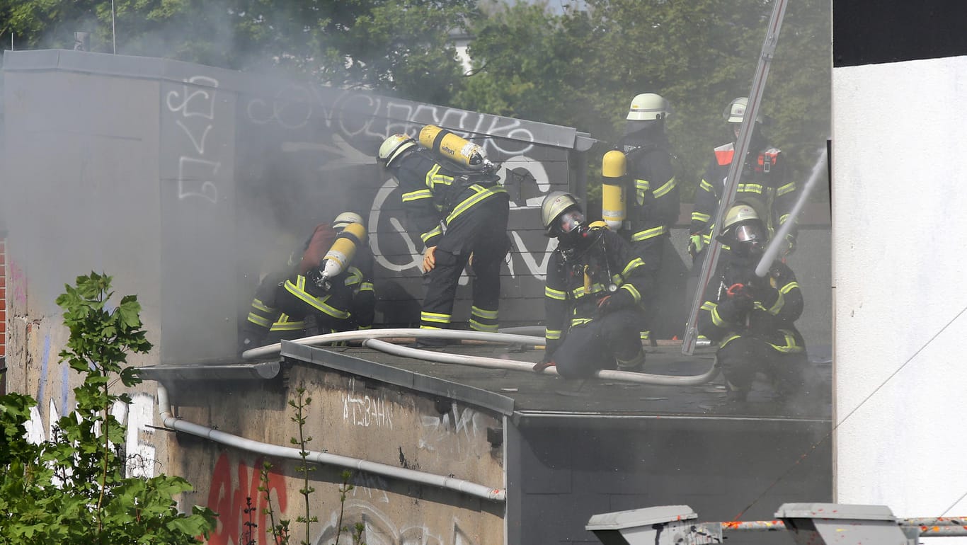 Brand im Schanzenviertel: Feuerwehrleute kämpfen vom Dach eines Nachbargebäudes aus gegen die Flammen.