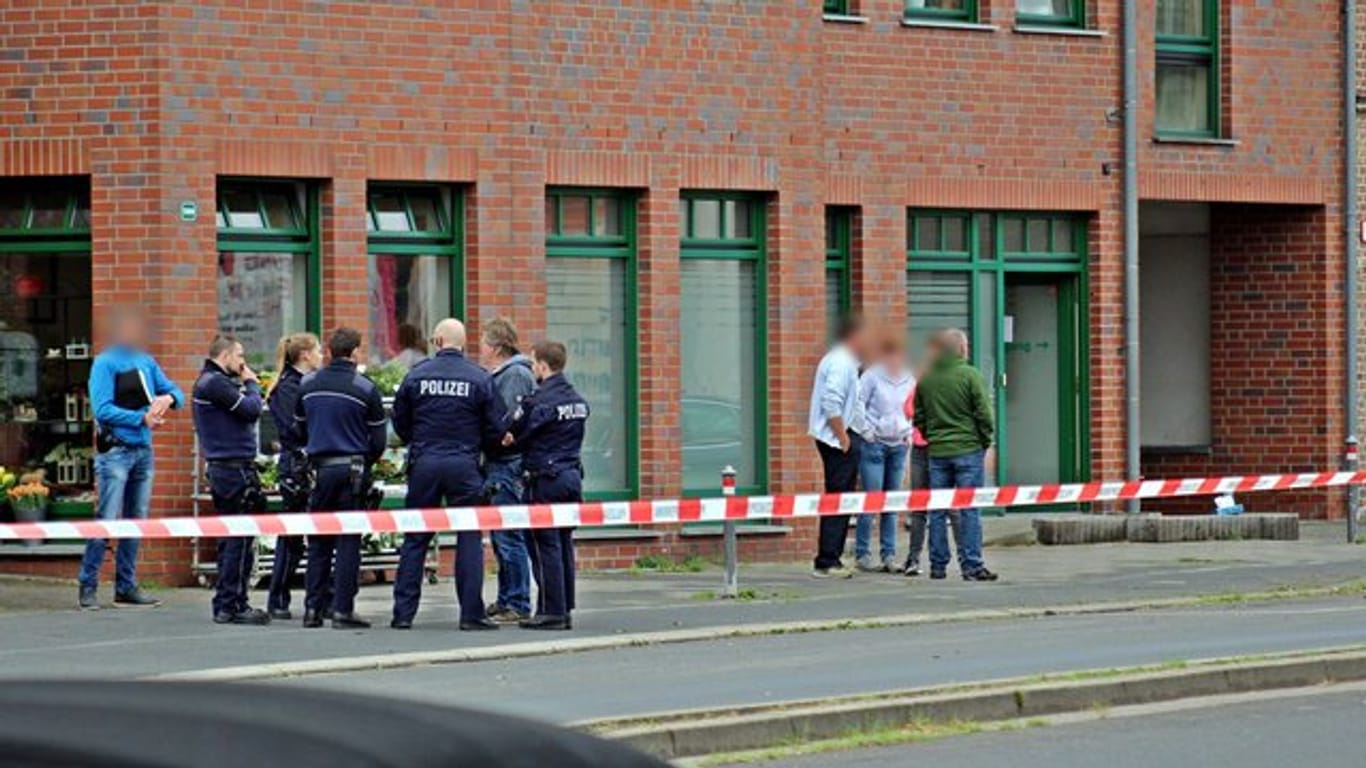 Polizeiabsperrung in Neuss: Vor einem Haus in der Innenstadt stehen Polizisten und Passanten.