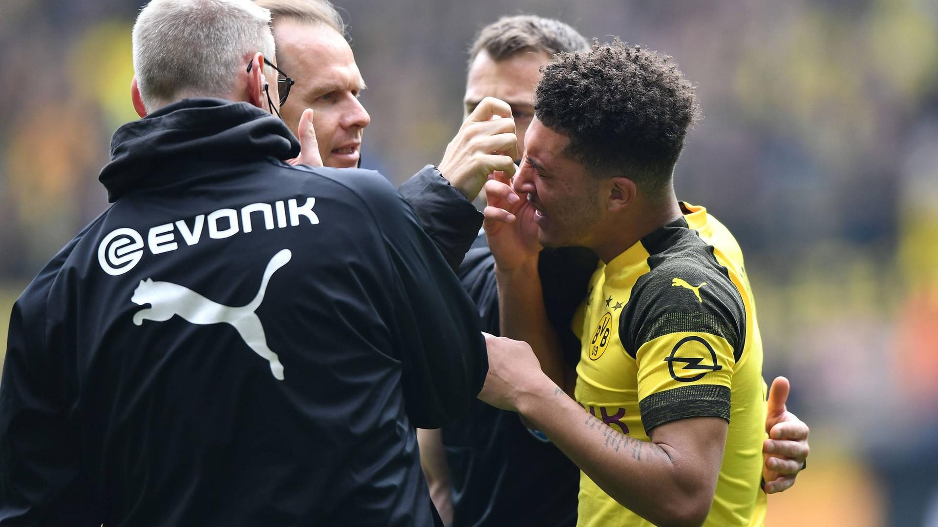 Nach einem Feuerzeugwurf: Jadon Sancho wird von BVB-Betreuern behandelt.