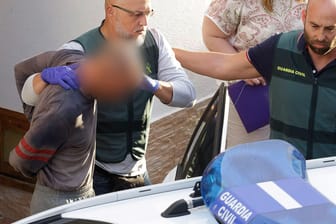 Adeje, Spanien: Der festgenommene Familienvater wird von Polizisten nach einer Hausdurchsuchung abgeführt.