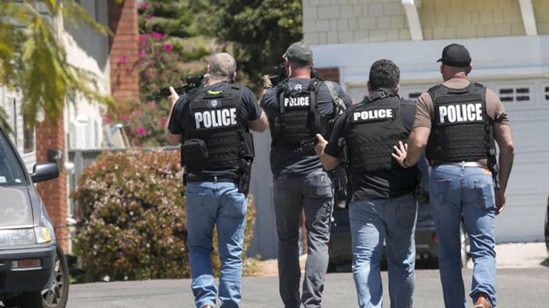 Schwer bewaffnete Polizisten aus San Diego nähern sich einem Haus, in dem der Täter eines Anschlags auf die Chabad of Poway Synagoge vermutet wird.