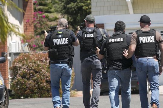 Schwer bewaffnete Polizisten aus San Diego nähern sich einem Haus, in dem der Täter eines Anschlags auf die Chabad of Poway Synagoge vermutet wird.