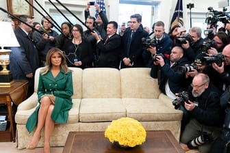 Melania Trump sitzt auf einem Sofa des Oval Office – an ihrer Seite zahlreiche Fotografen