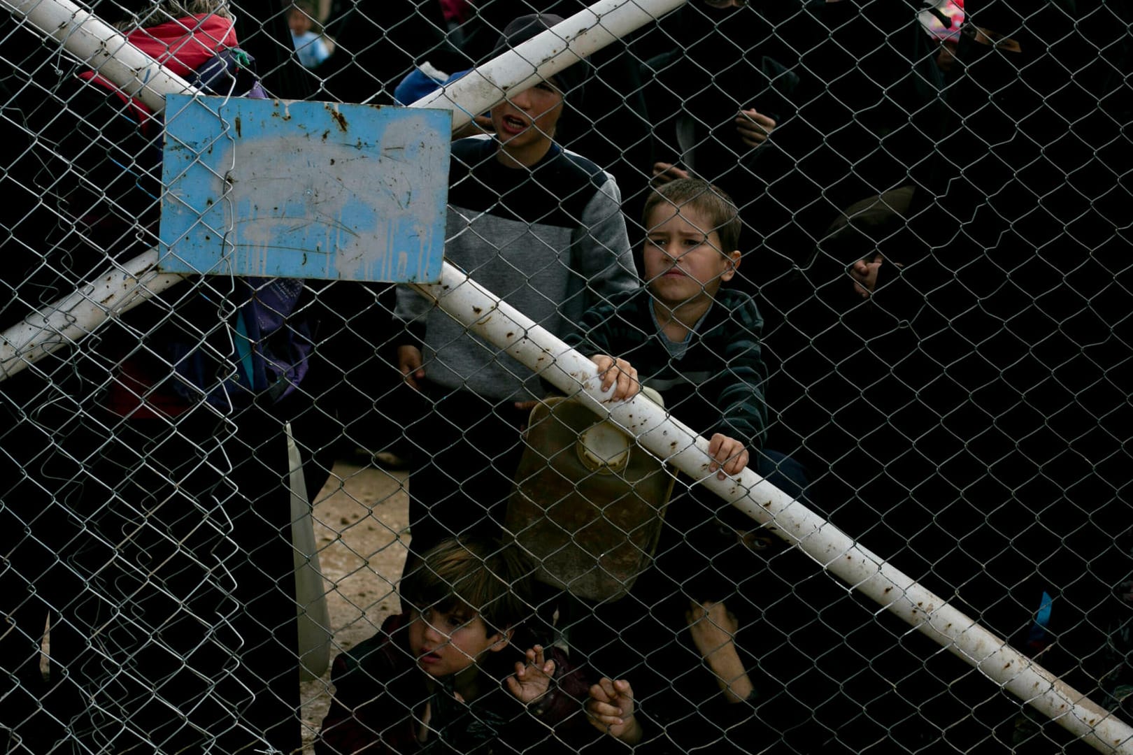 Kinder blicken von dem Tor ins al-Hul-Lager: Tausende IS-Kämpfer sind nach ihrer Aufgabe in Gefangenenlager gebracht worden, wo sie verhört werden. (Archivbild)