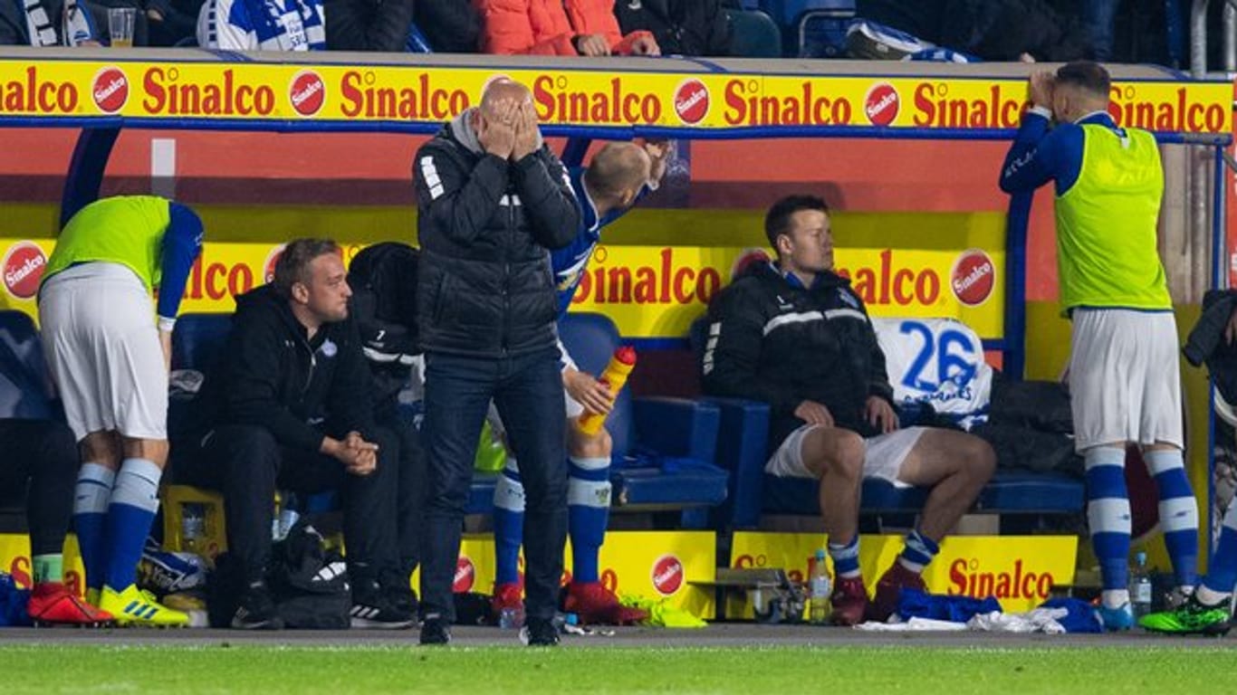 Duisburgs Trainer Torsten Lieberknecht steht beim Spiel gegen Bielefeld an der Trainerbank und schlägt die Hände vor das Gesicht.