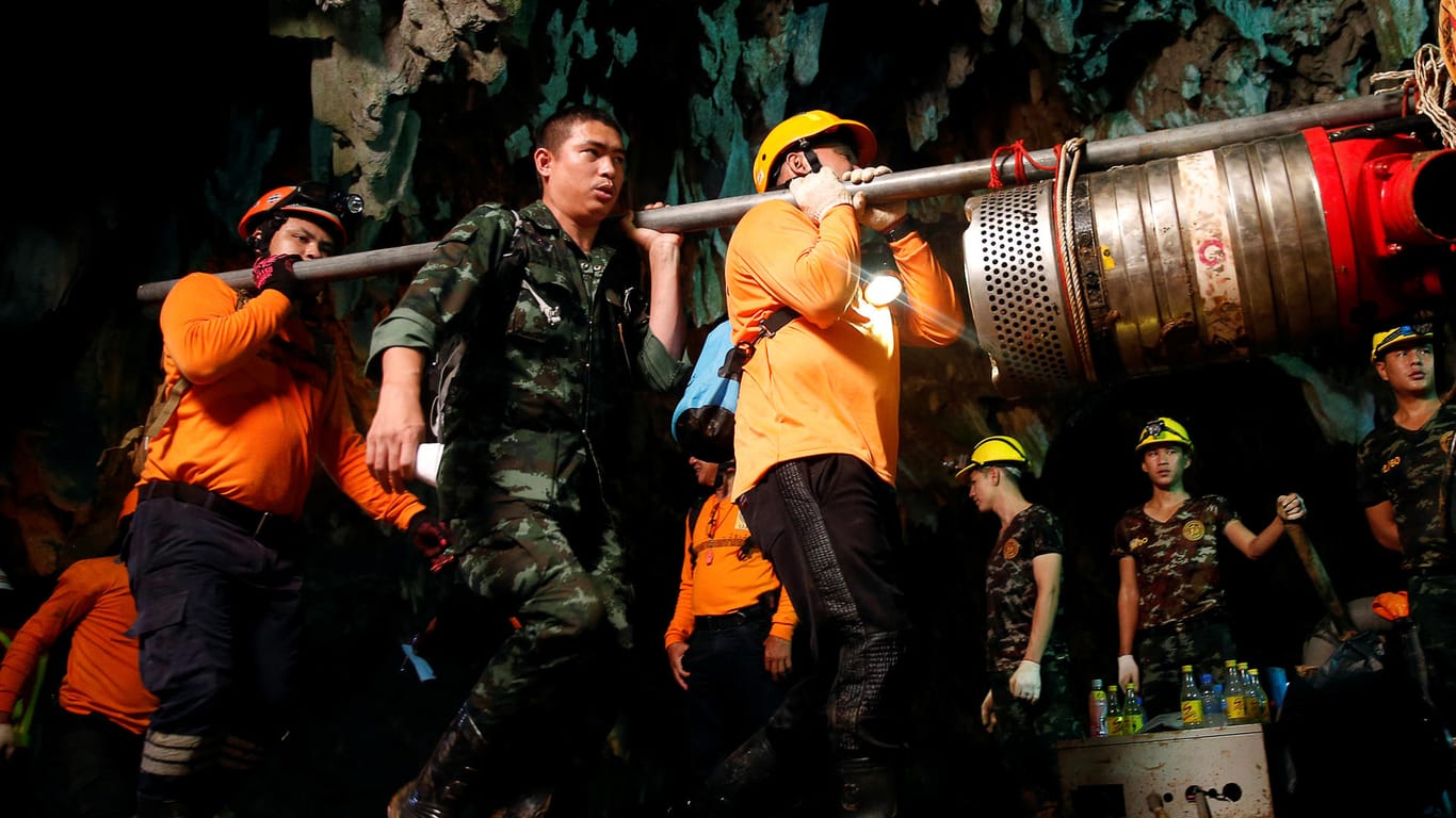 Helfer in Chiang Rai: Sie tragen die Maschinen und Werkzeuge nach der Rettung aus der Höhle heraus. (Archivbild)