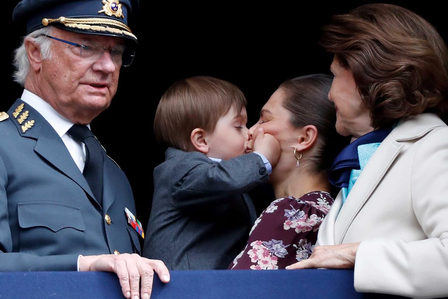 König Carl Gustaf mit Königin Silvia: Im Hintergrund gibt Prinz Oscar seiner Mama Victoria einen Kuss.