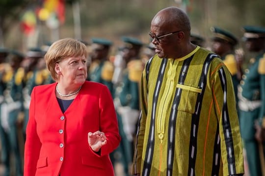 Bundeskanzlerin Angela Merkel wird mit militärischen Ehren von Burkina Fasos Staatschef Roch Marc Kaboré am Präsidentenpalast begrüßt.