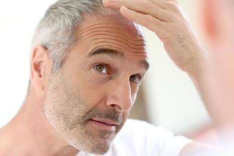 Mann kontrolliert seinen Kopf: Kann Koffein das Wachstum der Haare fördern?