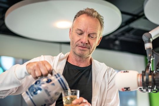 Sting besucht Radio FFH und gießt sich ein Glas hessischen Apfelwein ein.