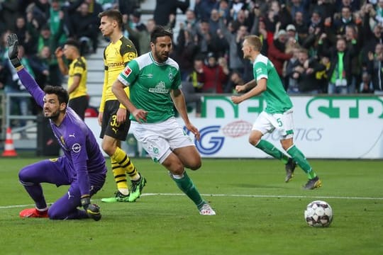 Bremens Torschütze Claudio Pizarro (M) hat den Treffer zum 2:2 erzielt während BVB-Torwart Roman Bürki (l) reklamiert.