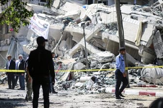 Polizisten und Einsatzkräfte stehen vor den Trümmern eines Gebäudes in Gaza, welches bei israelischen Luftangriffen auf die Stadt zerstört wurde.