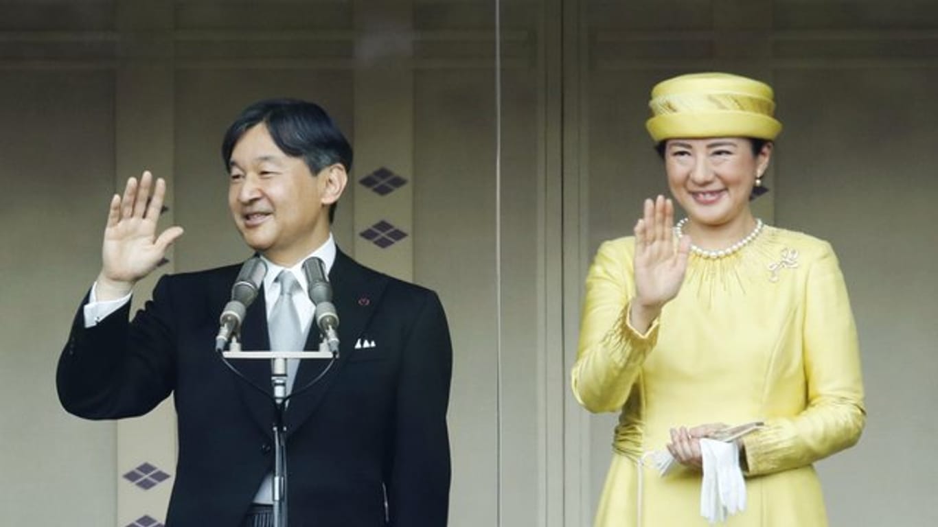 Japans neuer Kaiser Naruhito winkt mit Kaiserin Masako in die Menge.