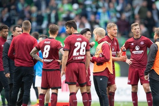 Nürnbergs Spieler stehen nach Spielschluss auf dem Feld und hadern mit der Niederlage.