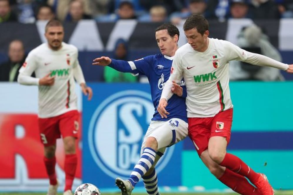 Schalkes Sebastian Rudy (l) spitzelt den Ball vor Augsburgs Michael Gregoritsch weg.