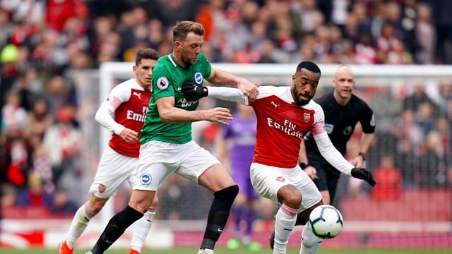 Stephens (l) von Brighton & Hove Albions kämpft mit Arsenals Lacazette um den Ball. Stephens (l) von Brighton & Hove Albions kämpft mit Arsenals Lacazette um den Ball.