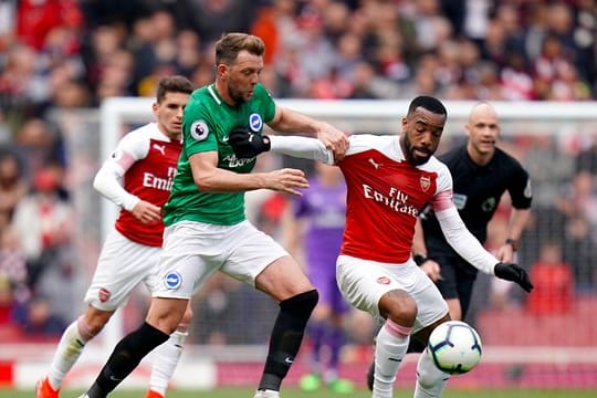 Stephens (l) von Brighton & Hove Albions kämpft mit Arsenals Lacazette um den Ball.