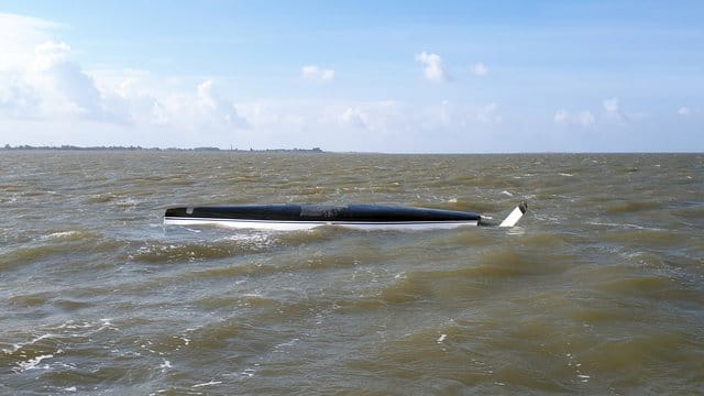 Gekentertes Segelboot treibt kieloben