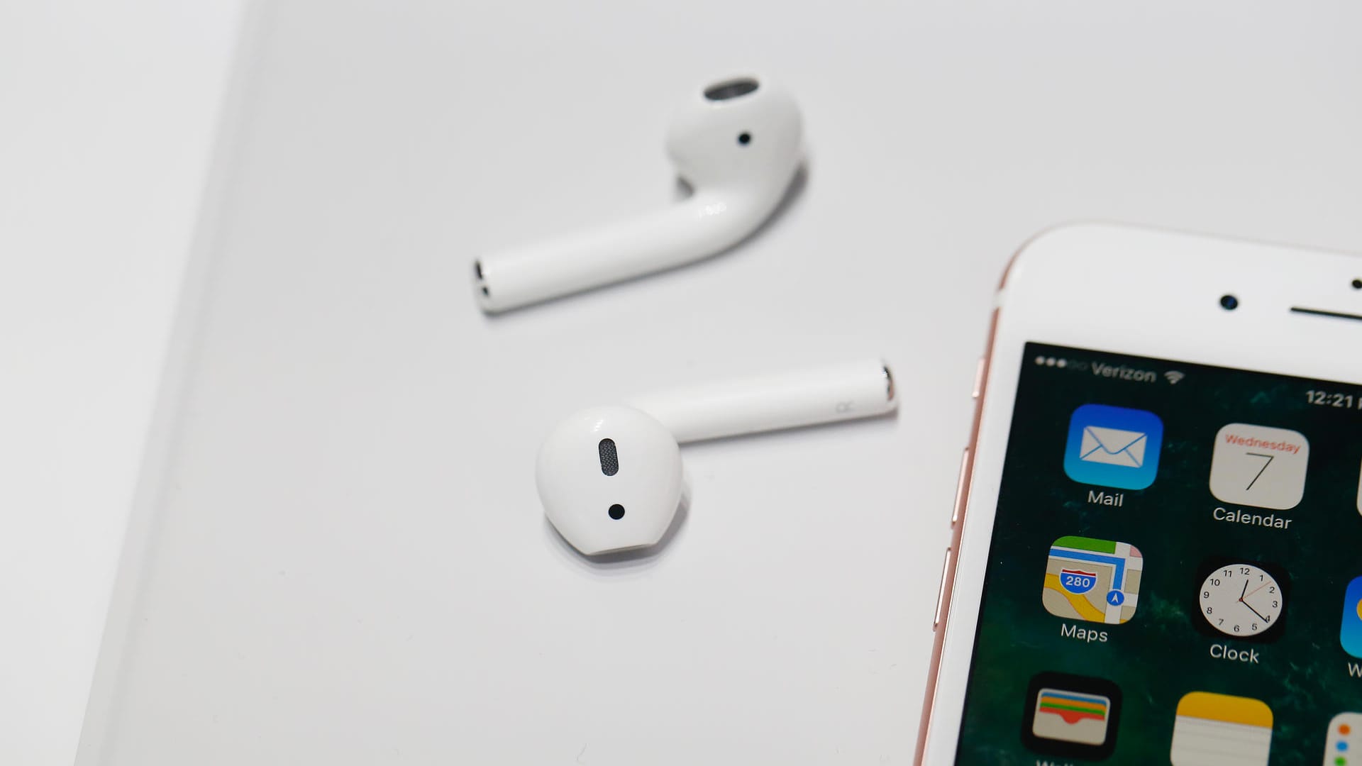 Apple AirPods neben einem iPhone: Die beliebten In-Ear-Kopfhörer sind zum Sport und im Alltag beliebt.