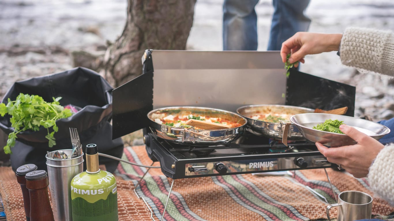 Kochen im Freien: Der Campingkocher und Grill brauchen oft einen Windschutz.