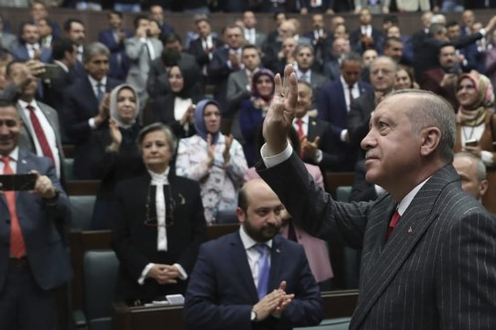 Recep Tayyip Erdogan winkt Anhängern im Parlament.